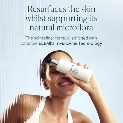 Woman holding ELEMIS skin refiner bottle, promoting skin resurfacing and natural microflora support.